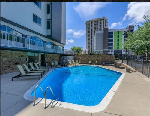 a swimming pool with chairs and a building at 5 STAR APT in Towson