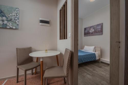 Habitación con mesa, sillas y cama en Kosmos Service Apartment Absolute City Center 1-5 With Additional Cost Parking, en Tesalónica