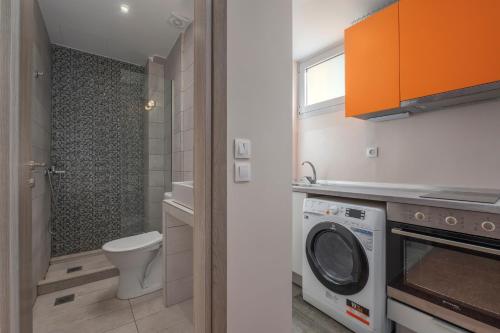 a bathroom with a toilet and a washing machine at Kosmos Service Apartment Absolute City Center 1-5 With Additional Cost Parking in Thessaloniki