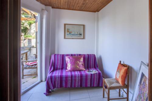 un sofá púrpura en una habitación con ventana en Casa Pinzelli, en Farinole