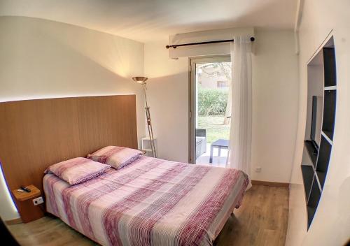 une chambre avec un lit et une porte coulissante en verre dans l'établissement Golf Juans- 2P résidence avec Piscine, Plages 300m, à Vallauris