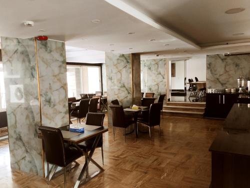 Un restaurante con mesas y sillas en una habitación. en Golden Plaza Hotel, en Amán