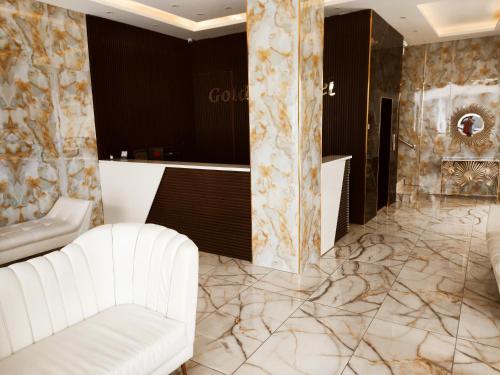 a living room with a white couch and marble floors at Golden Plaza Hotel in Amman