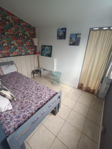een kleine slaapkamer met een bed en een raam bij Cabane in Andernos-les-Bains