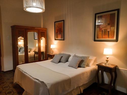 a bedroom with a bed with two lamps and a mirror at Posada Finca Garciarena in Agrelo