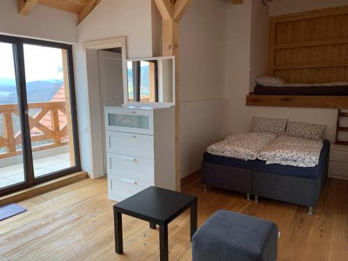 a bedroom with a bed and a dresser and a window at Apartmány Podhorie, Banská Štiavnica in Banská Štiavnica