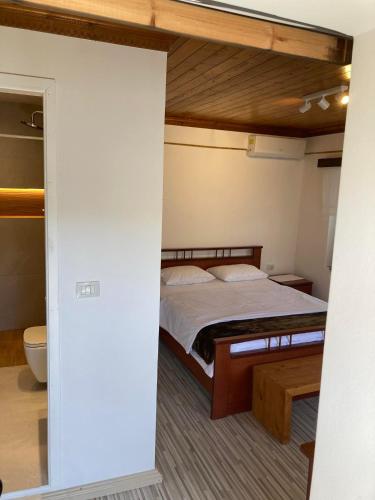 a bedroom with a bed with a wooden bed frame at Sokaku i te Marreve GuestHouse in Gjirokastër
