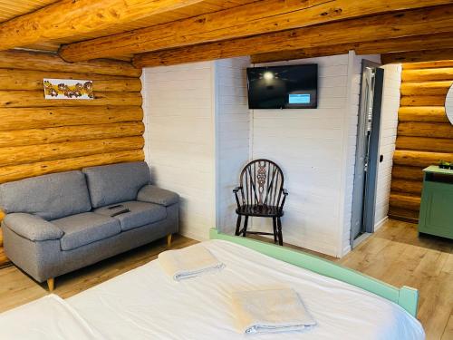 um quarto com uma cama, um sofá e uma televisão em Cabana din Groapa Frumoasa em Rasnov