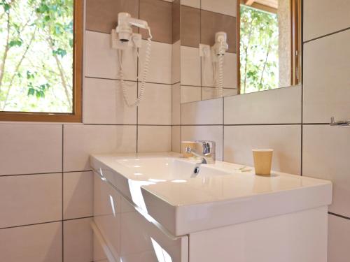 une salle de bain avec un lavabo blanc et un miroir dans l'établissement Kallisterra, à Sainte-Lucie de Porto-Vecchio