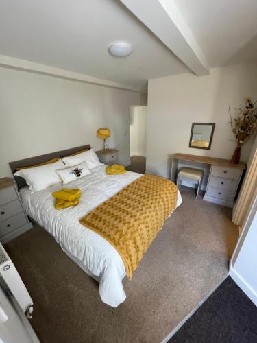a bedroom with a large bed and a desk at The Hive in South Molton