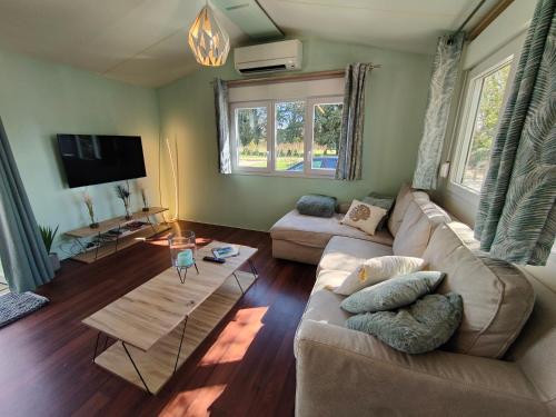 a living room with a couch and a tv at Cocon familial à la ferme in Eyragues