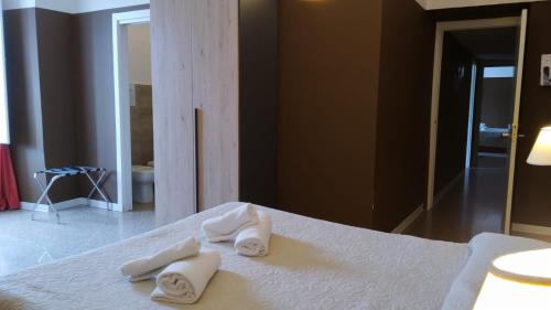 ein Schlafzimmer mit einem Bett mit weißen Handtüchern darauf in der Unterkunft CconfortHotels R&B Central Rooms - SELF CHECK IN in Bari