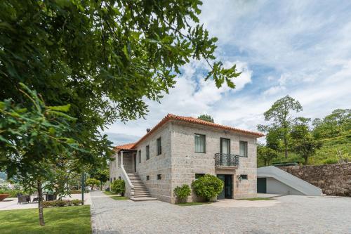 a stone house with a staircase on the side of it at Quinta das Piramides in Vila Nova de Famalicão