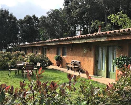 Amazing 4-Bed Cottage lost in Montseny Nature في أربوثياس: منزل من الطوب مع طاولة وكراسي في الفناء