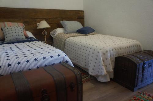 um quarto com duas camas e uma mala em Amazing 4-Bed Cottage lost in Montseny Nature em Arbúcies