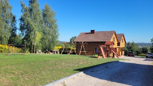 a house with a playground in front of a yard at Wrzosowe Wzgórze Domek 3 sypialnie in Chęciny