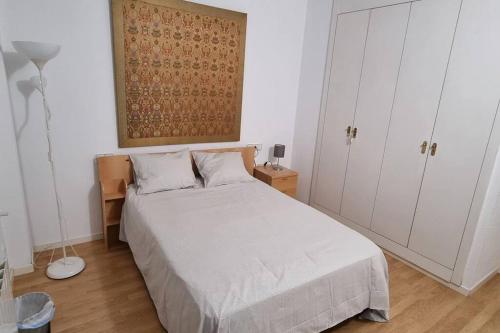 a bedroom with a white bed and white cabinets at Habitación Privada en el Centro de Madrid in Madrid
