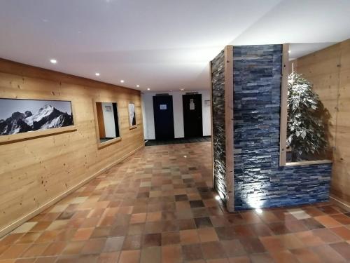 a hallway with a tile floor and a stone wall at Studio de 32 m2 pour 3 personnes pied des pistes in Les Deux Alpes
