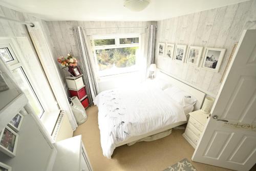 a bedroom with a white bed and a window at Eagles View Private Cottage - Betws Y Coed in Betws-y-coed