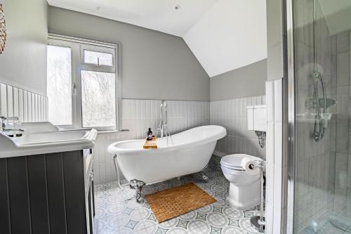 een badkamer met een bad, een toilet en een wastafel bij Suitable For Contractors 2 Double Beds and Sofa Bed Private Parking in Harlow