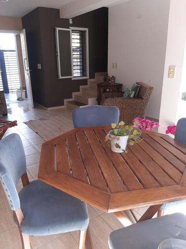 una mesa de madera y sillas en la sala de estar. en Departamentos Angenino Lujan en Luján de Cuyo