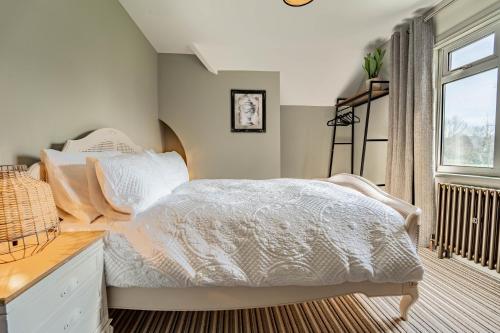 a bedroom with a white bed and a window at 3-Bedroom Cottage with Parking Sleeps 6 in Harlow