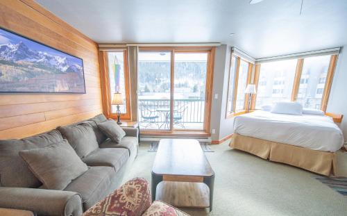 ein Wohnzimmer mit einem Sofa und einem Bett in der Unterkunft Lakeside 1476 in Keystone