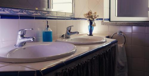 La salle de bains est pourvue de 2 lavabos et d'un vase de fleurs. dans l'établissement Quinta Castanheiro da Penha - Alegrete - Portalegre - Alentejo, à Alegrete
