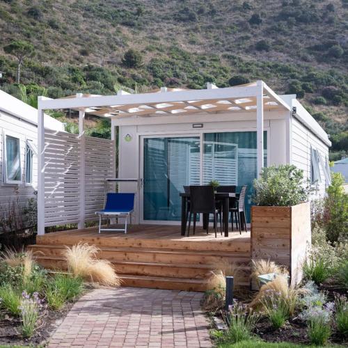 a house with a deck with a table and chairs at Le Palme Village in Terracina