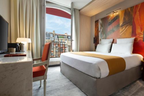 パリにあるメルキュール パリ アレシアのベッド、デスク、窓が備わるホテルルームです。