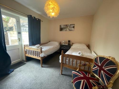 a bedroom with two beds and a window and a chandelier at South Dene Hotel in Bridlington