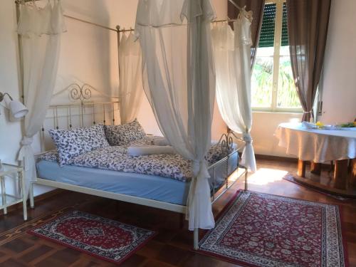 een slaapkamer met een bed met gordijnen en een tafel bij Villa del Cigno in Lecco