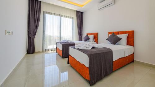 2 camas en una habitación con ventana grande en Atlantis - 4 Bedroom Holiday Villa in Hisaronu en Ölüdeniz