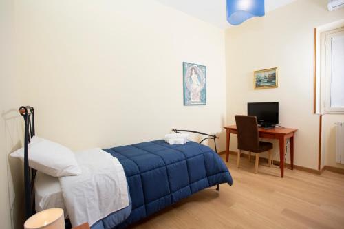 een slaapkamer met een bed en een bureau met een computer bij CASA CANNEZIO in Ragusa