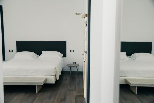 a bedroom with two beds and a mirror at Hotel Villa Sorriso in Lido di Jesolo