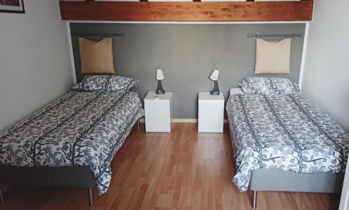 a bedroom with two beds and two lamps at La Picci in Catania