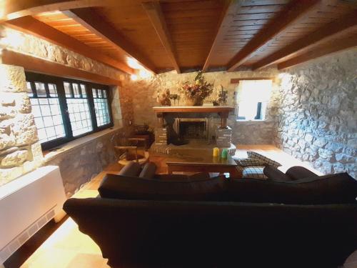 a living room with couches and a stone fireplace at Chalet Montagne 