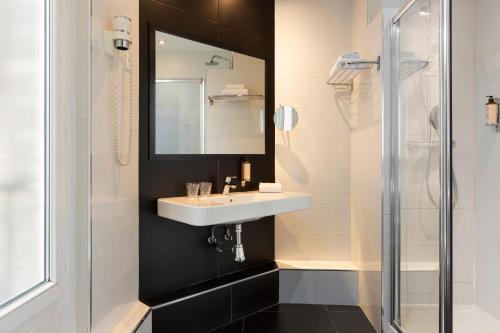 een badkamer met een wastafel en een douche bij Mercure Paris Alesia in Parijs