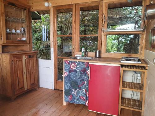 - une cuisine dans une petite maison avec un réfrigérateur rouge dans l'établissement Agricamping La Gallinella, à Castagneto Carducci