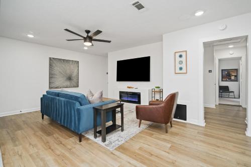 a living room with a blue couch and a table at The Gated Modern Home Near NRG and Medical Center in Houston
