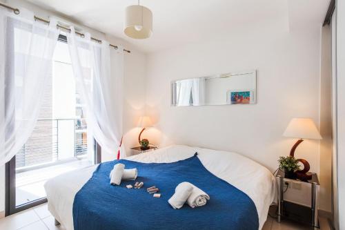 - une chambre avec un lit bleu et blanc et des serviettes dans l'établissement VICTOR HUGO AP4159 Nice, by Riviera Holiday Homes, à Nice