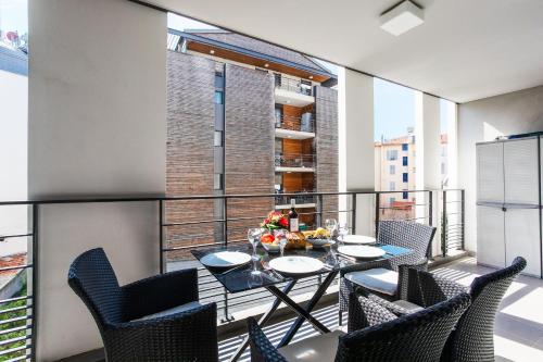 un balcon avec une table et des chaises et une grande fenêtre dans l'établissement VICTOR HUGO AP4159 Nice, by Riviera Holiday Homes, à Nice