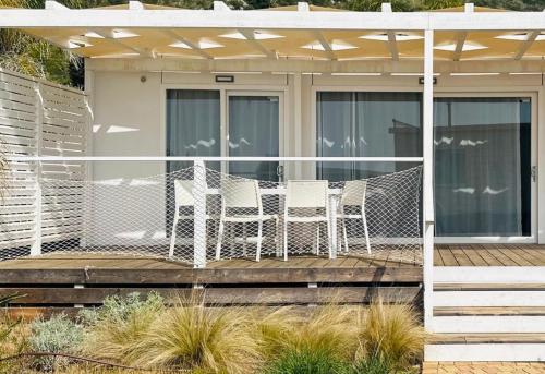 a patio with two chairs and a table on a deck at Le Palme Village in Terracina