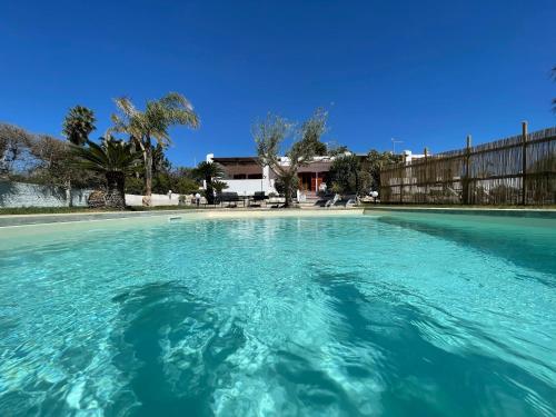 une grande piscine d'eau bleue dans une cour dans l'établissement Villa Sara - Villa con piscina, à Marina di Ragusa