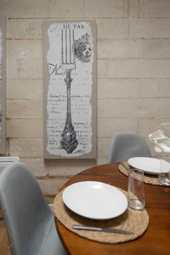 a wooden table with two white plates on top of it at Magnifique T2 avec balcon centre-ville in Cognac