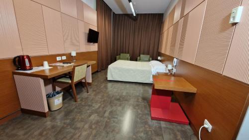 Habitación hospitalaria con cama, escritorio y mesa en Bella Italia Palace Hotel, en Novara
