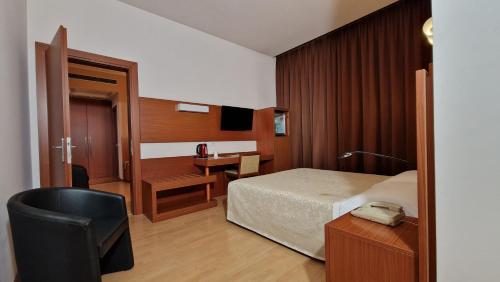 a bedroom with a bed and a desk and a chair at Bella Italia Palace Hotel in Novara