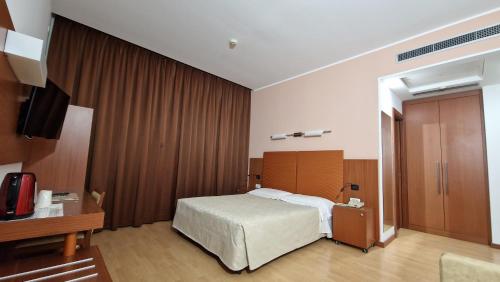a hotel room with a bed and a television at Bella Italia Palace Hotel in Novara