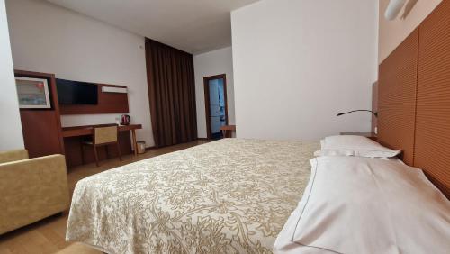 a hotel room with a bed and a desk at Bella Italia Palace Hotel in Novara