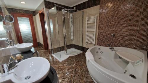 a bathroom with a tub and a sink and a shower at Bella Italia Palace Hotel in Novara